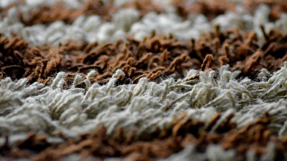 Een hoogpolig tapijt van bruine en beige wol.