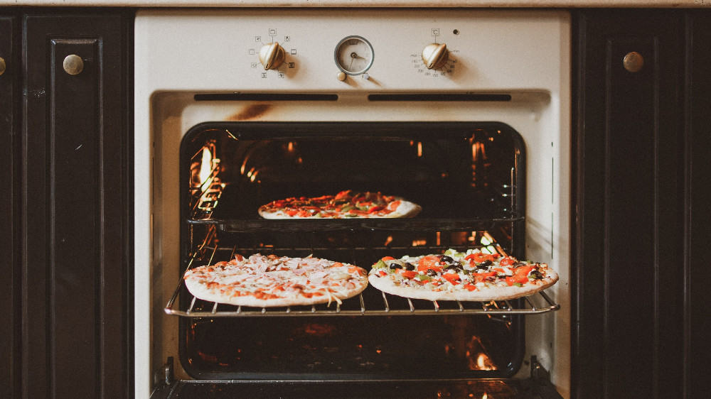 Twee pizza's in een vintage oven