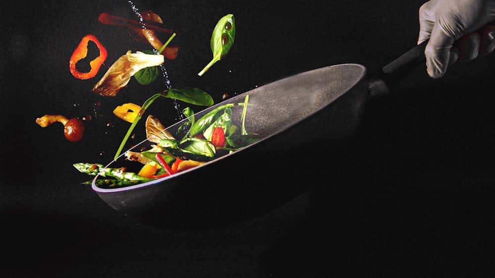 Wokpan met groenten op zwarte achtergrond