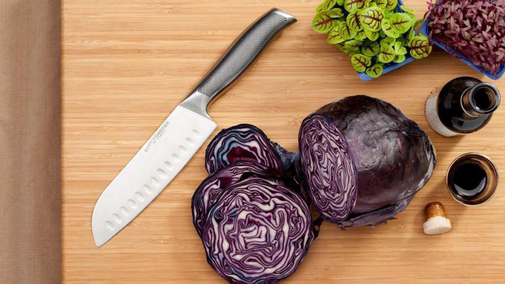 Snijplank met mes en groenten erop.