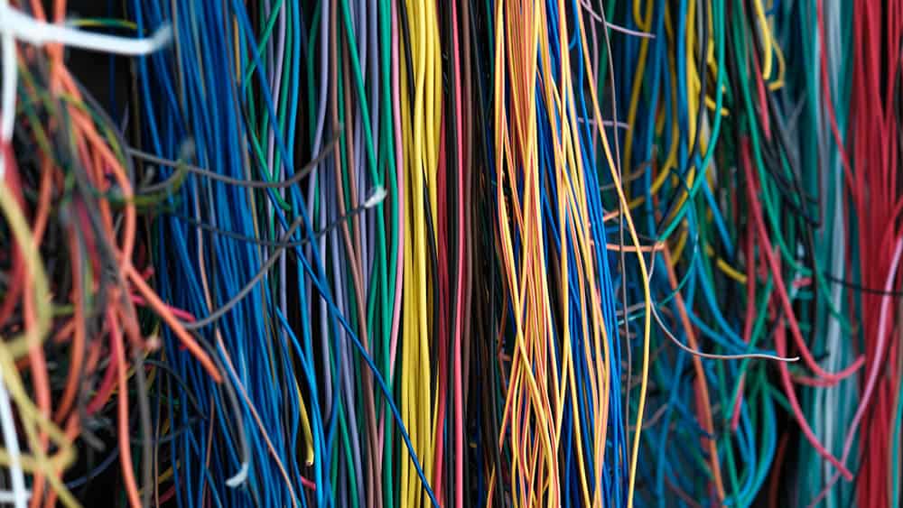 Veel hangende kabels in allerlei kleuren.