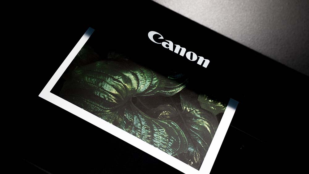 Een zwarte fotoprinter van Canon print een foto
