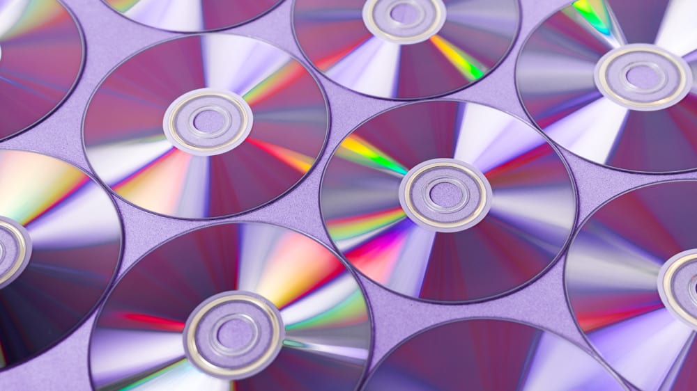 cd's liggen naast elkaar op een roze achtergrond