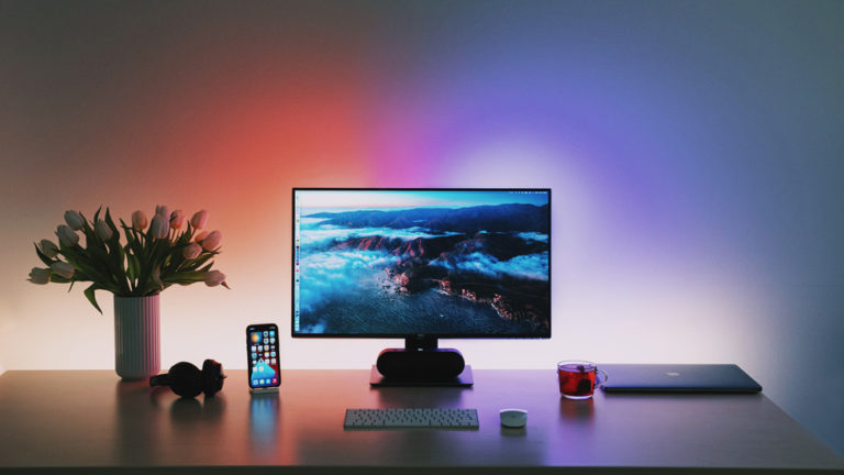 bureau met computer wordt verlicht door slimme verlichting in verschillende kleuren