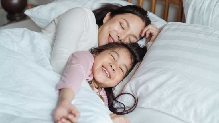 Vrouw en kind liggen samen in bed