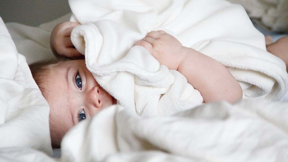 Een baby knuffelt met een dekentje