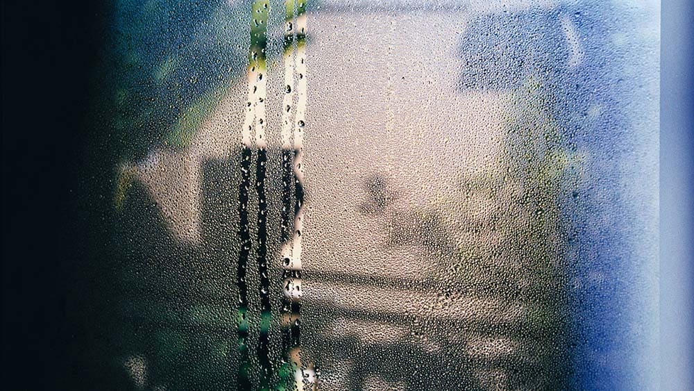 Een raam met vocht en regendruppels