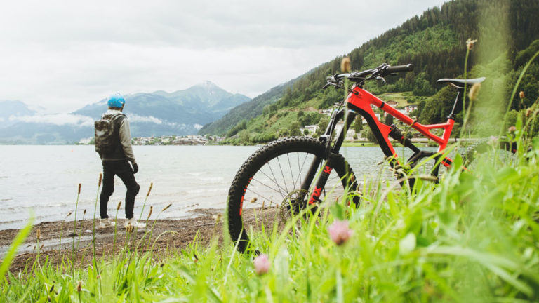 Mountainbike met op de achtergrond een man in een landschap.