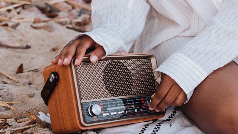 Vrouw stelt Dab+-radio in op het strand