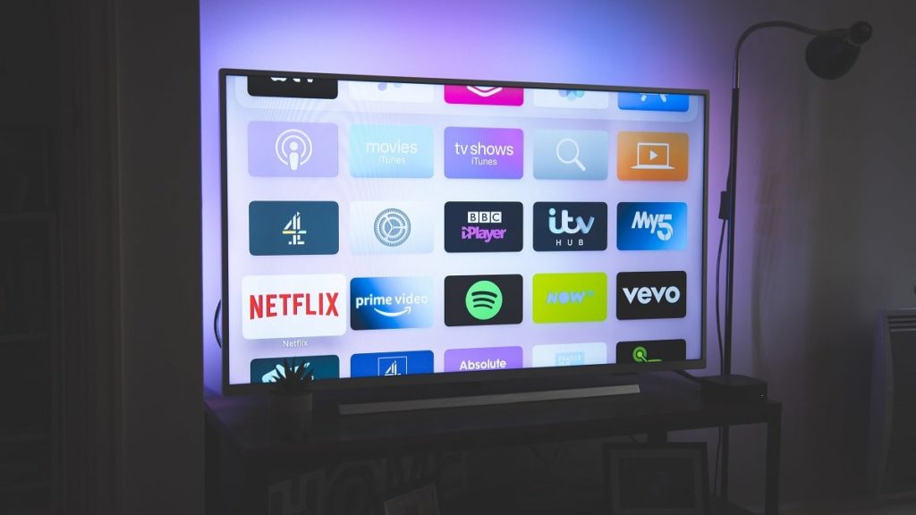 Een smart-tv in een donkere kamer met allemaal verschillende apps op het scherm