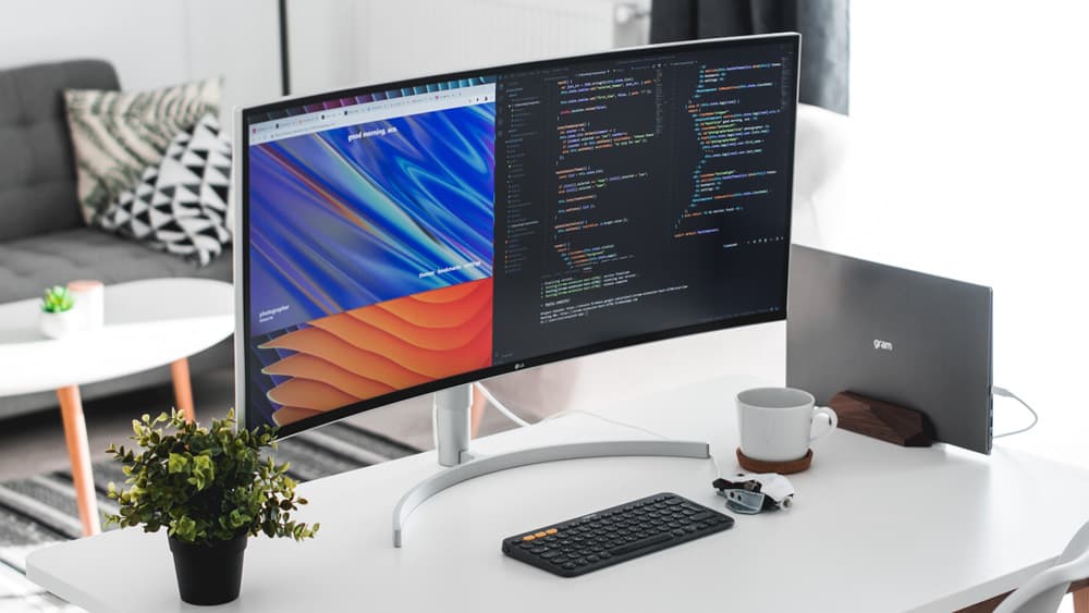een curved monitor staat op een bureau in een huis