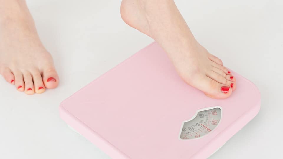 voeten stappen op een roze analoge weegschaal